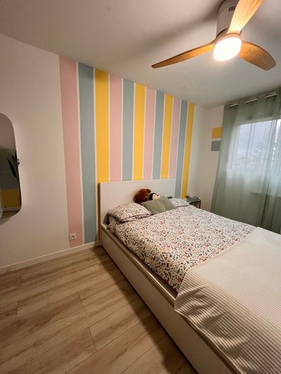 Vue d'ensemble de la chambre d'enfant avec fresque murale à rayures pastel